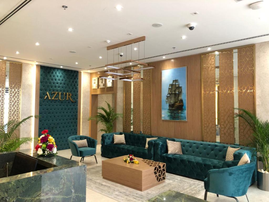 Azur Regency Hotel Apartments في دبي: غرفة معيشة مع أريكة وكراسي زرقاء