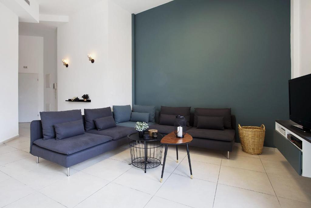 a living room with a blue couch and a table at Flea Market 1BR - 30 09 Olei Zion St Tel Aviv in Tel Aviv