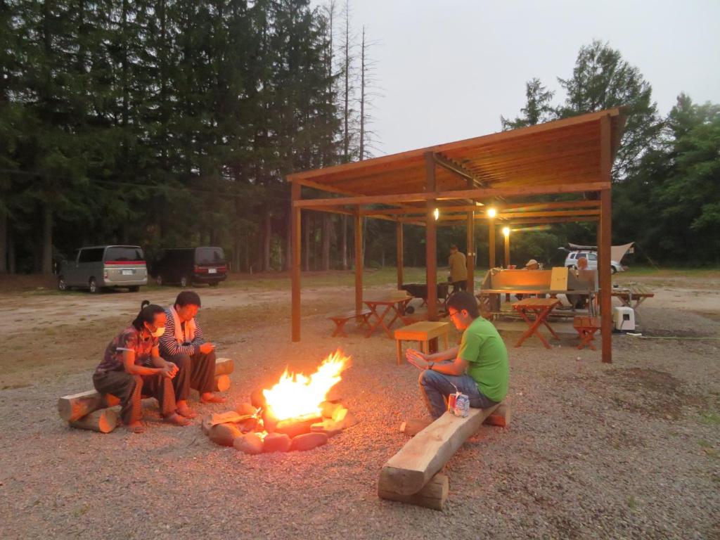 Eine Gruppe von Menschen, die um ein Feuer herum sitzen in der Unterkunft Mizu no Gakko in Shari