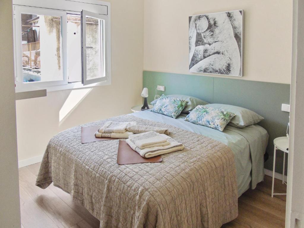 布拉內斯的住宿－CozyCatalonia - Comfortable Apartment in Central Blanes，一间卧室配有一张床,上面有两条毛巾