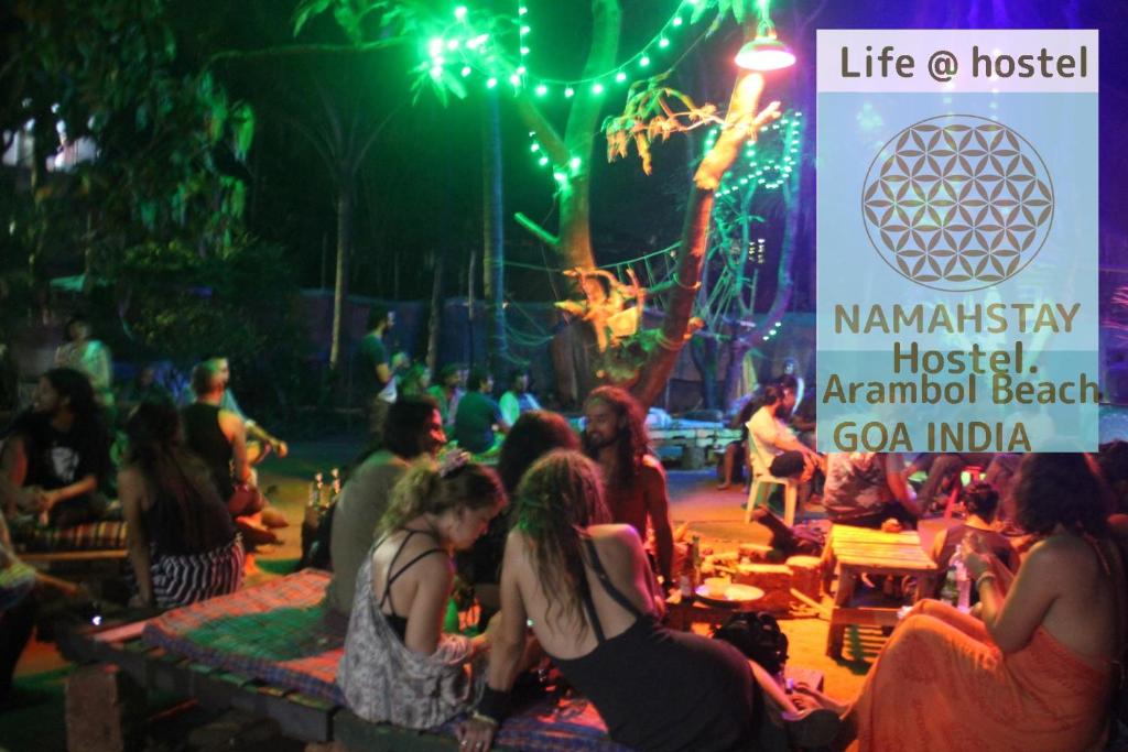 een groep mensen die rond een podium op een feest zitten bij NamahStay Hostel, Cowork & Artist residency Arambol in Arambol
