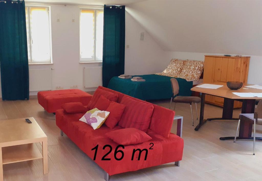 ein Wohnzimmer mit einem roten Sofa und einem Bett in der Unterkunft Abra-fed apartament Kalinówka in Lublin