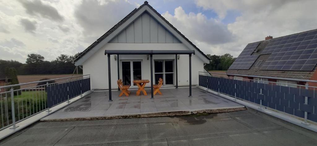 ein kleines weißes Haus mit zwei Stühlen auf einer Terrasse in der Unterkunft Am Habichtsweg 2te. in Lengerich