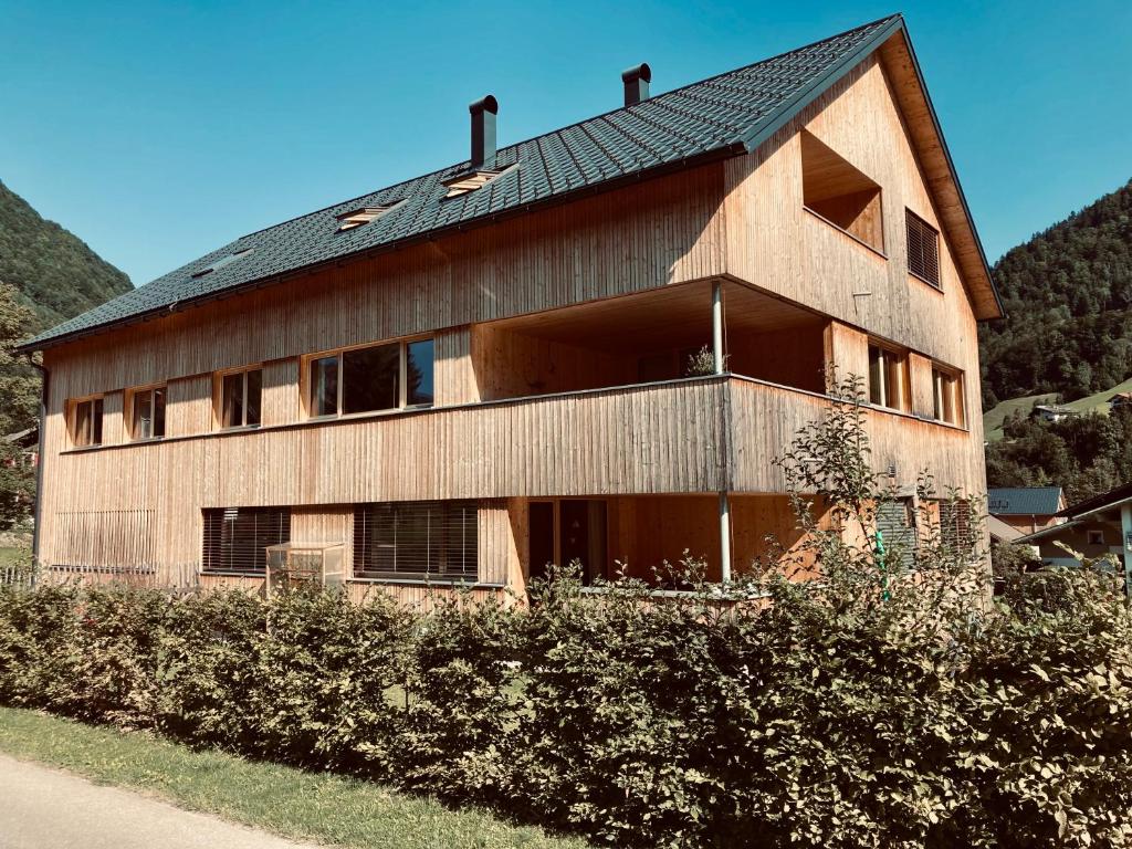 a large wooden building with a black roof at hus56 in Mellau