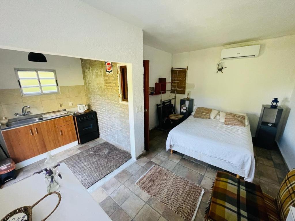 a bedroom with a bed and a kitchen with a sink at Costa Villa in Atlántida