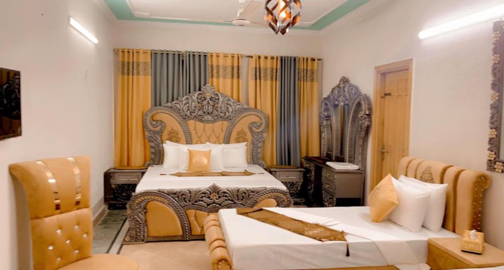 a bedroom with two beds and a table and chairs at Galaxy Lodge in Islamabad