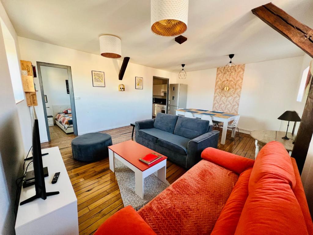 een woonkamer met een bank en een tafel bij Appartement coeur centre-ville cosy et chaleureux rue Carnot in Châlons-en-Champagne