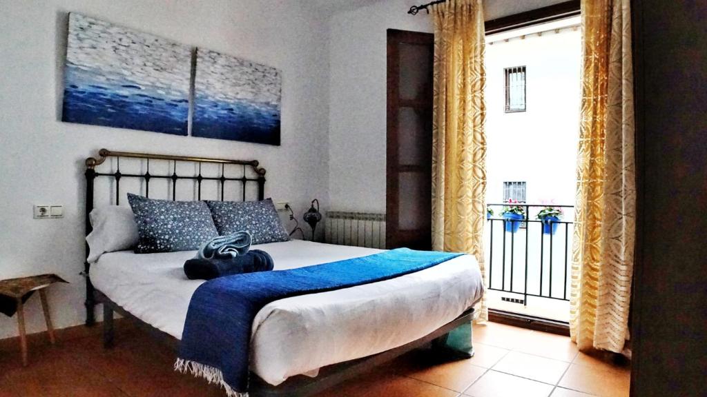 a bedroom with a bed with a blue blanket on it at Entre Dos Aguas in Granada