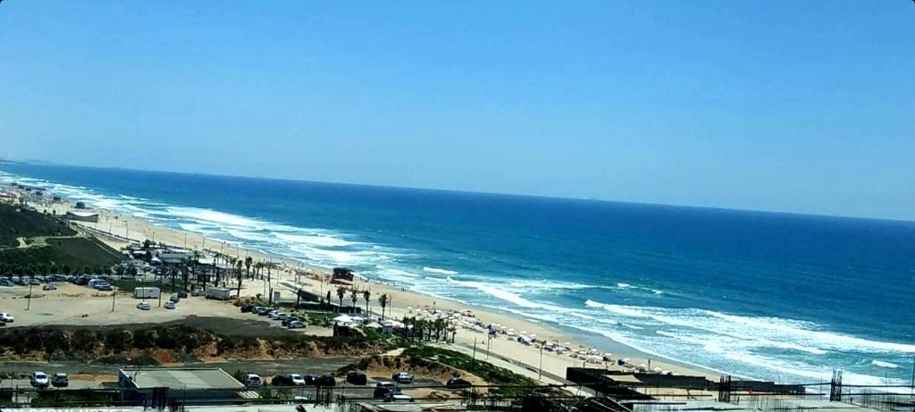 uma vista para uma praia com pessoas e para o oceano em מלון דירות על הים בת ים 39 em Bat Yam