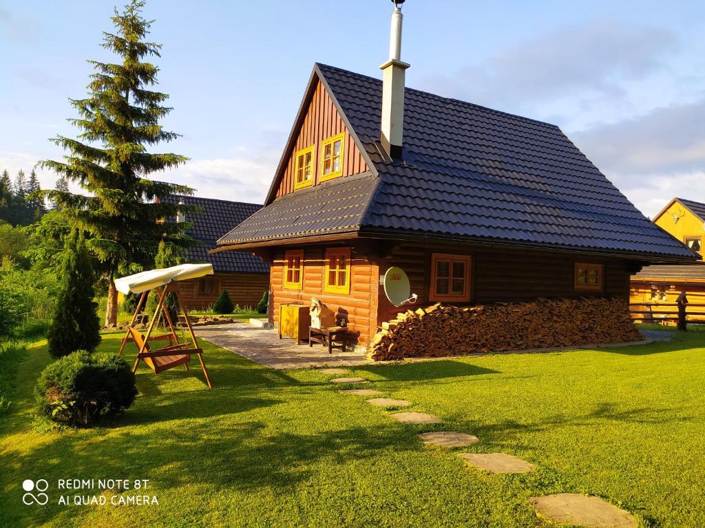 a large wooden house with a gambrel roof at Chata U Juraja in Hruštín