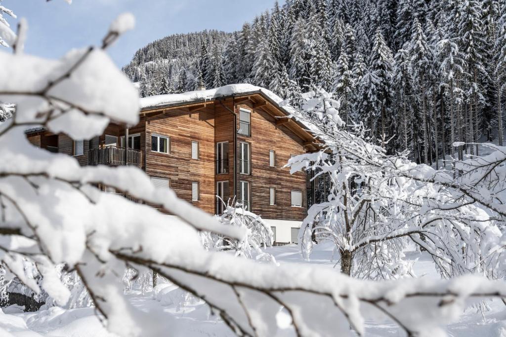 a log cabin in the snow with snow covered trees at Bad Ratzes in Siusi