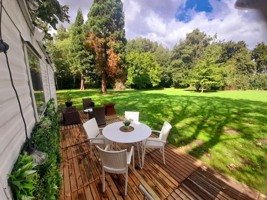 een houten terras met een tafel en stoelen erop bij Delightful tiny home in the middle of nature. 