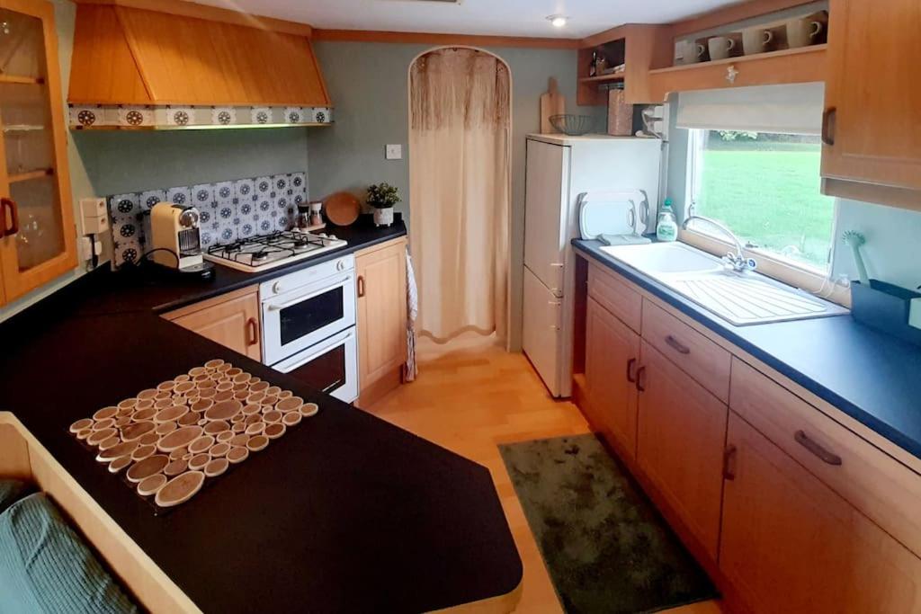 a kitchen with a table and a stove and a refrigerator at Delightful tiny home in the middle of nature. 