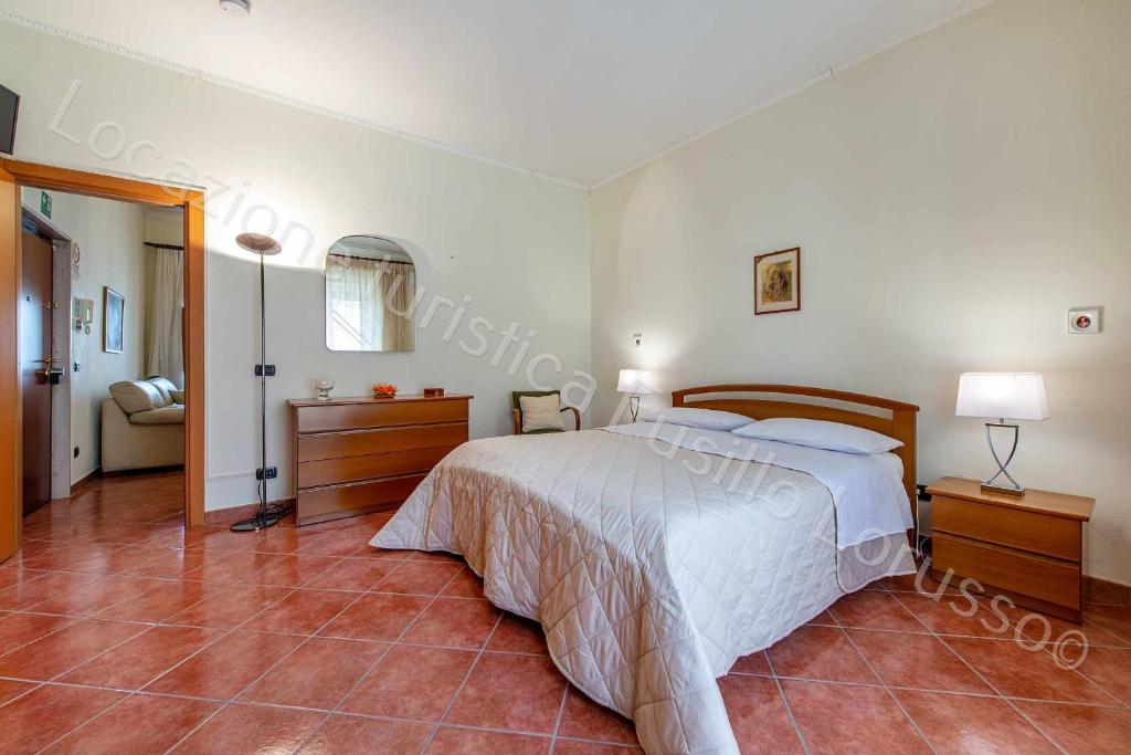 um quarto com uma cama branca e piso em azulejo em Locazione turistica Lorusso em Andria