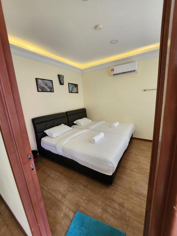 a bedroom with a bed with white sheets and pillows at LTH (Little Turtle's Home) in Semporna