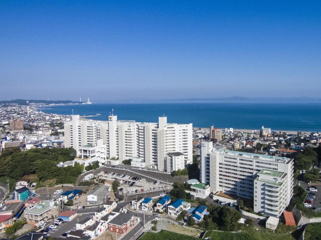 an aerial view of a city with buildings and the ocean at Maholova Minds Miura in Miura
