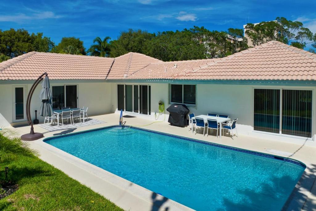 a swimming pool in front of a house at Sail Away Beach Cottage Sleeps 10 Heated Pool in Fort Lauderdale