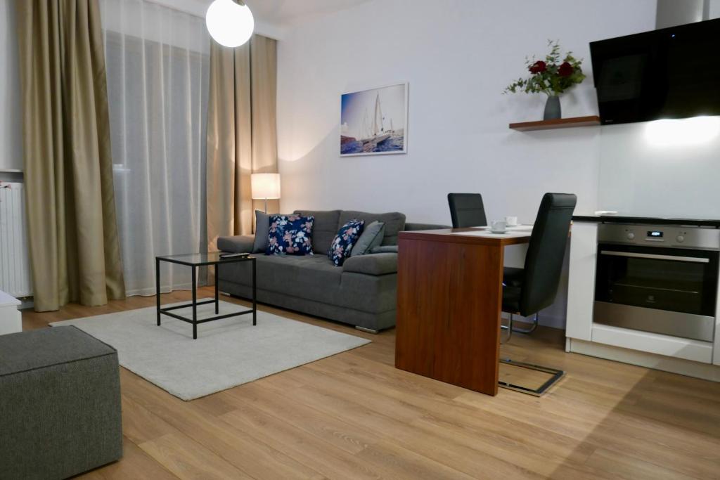 a living room with a couch and a table at Zdrowa Apartment in Wilanów in Warsaw