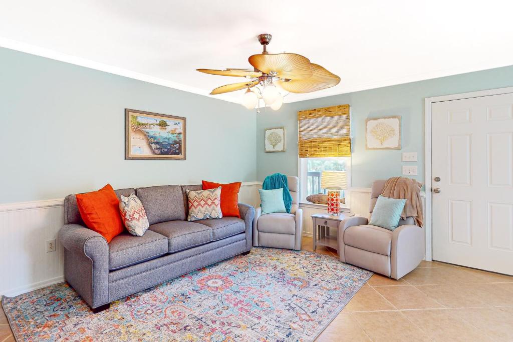 a living room with a couch and two chairs at Sunset Breeze #4 in Dauphin Island