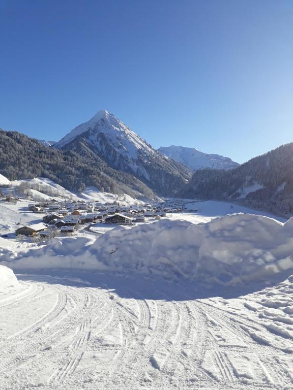 a pile of snow on a ski slope with a mountain at Fernblick Frühstückspension in Schoppernau