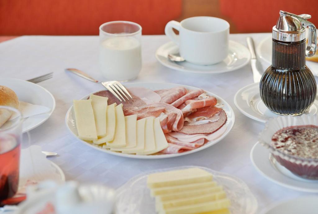 a table topped with a plate of cheese and meat at Fernblick Frühstückspension in Schoppernau