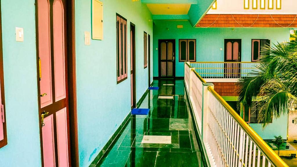 een lege hal van een gebouw met groene en blauwe muren bij Srinivasa Residency in Mahabalipuram