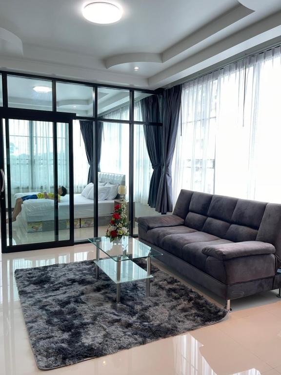 a living room with a couch and a glass table at Service Apartment ใจกลางเมืองใกล้แหล่งท่องเที่ยว119ทับ1ถนนปงสนุก in Lampang