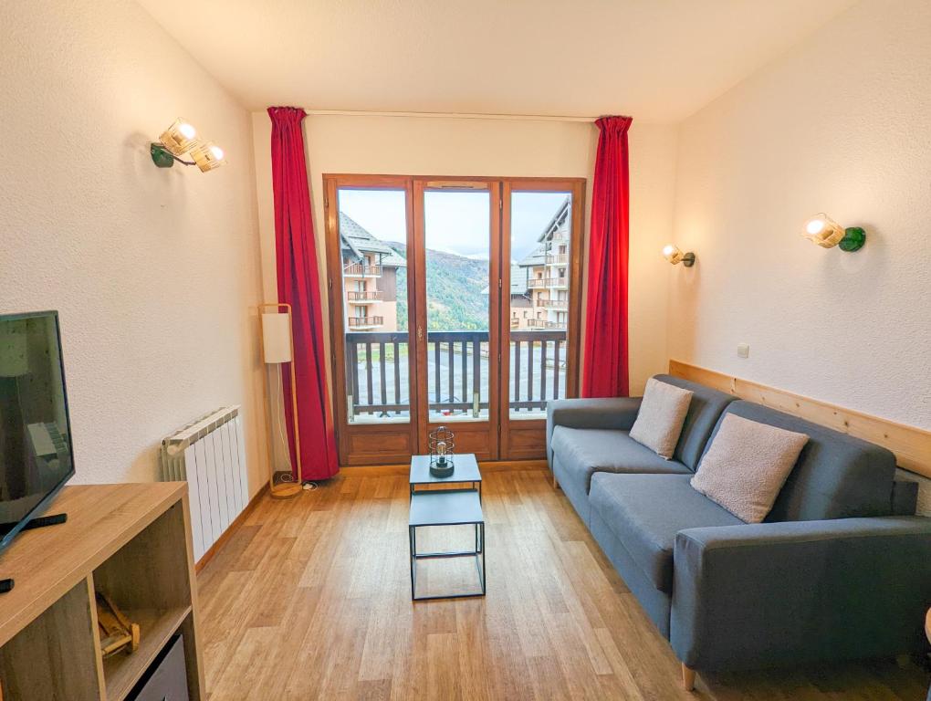 a living room with a couch and a large window at Appartement 2/4 pers, Résidence 4* Les Hauts de Valmeinier, Centre station in Valmeinier