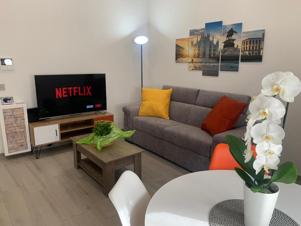 a living room with a couch and a tv at Ripa150 - Smart Apartament Milano in Milan