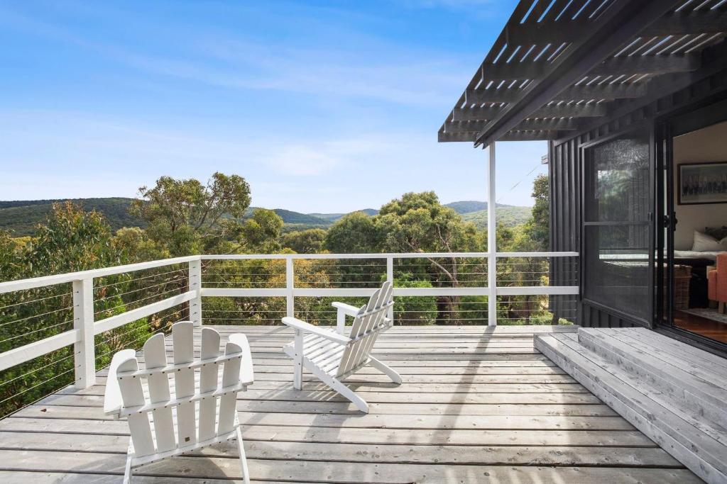 two white chairs on a deck with a view at Moggs Magic in Aireys Inlet