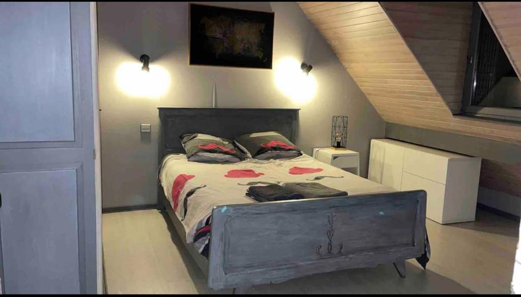 een slaapkamer met een groot bed met een houten hoofdeinde bij Chambre privée au cœur des Pyrénées in Luz-Saint-Sauveur