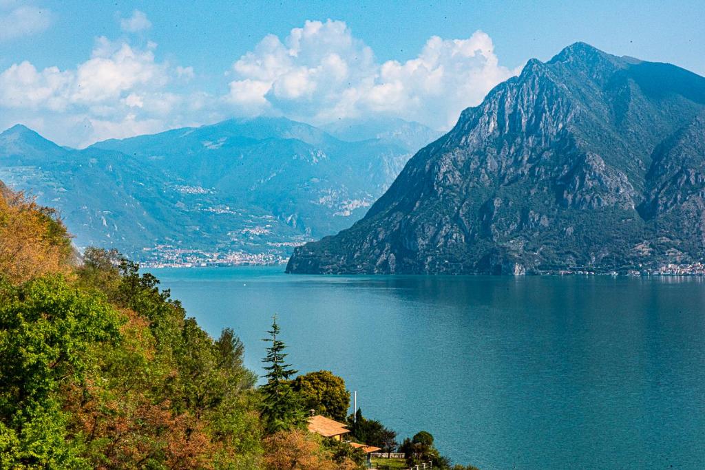 - une vue sur une étendue d'eau avec des montagnes dans l'établissement Italian Vacation Homes - Gemini, à Tavernola Bergamasca