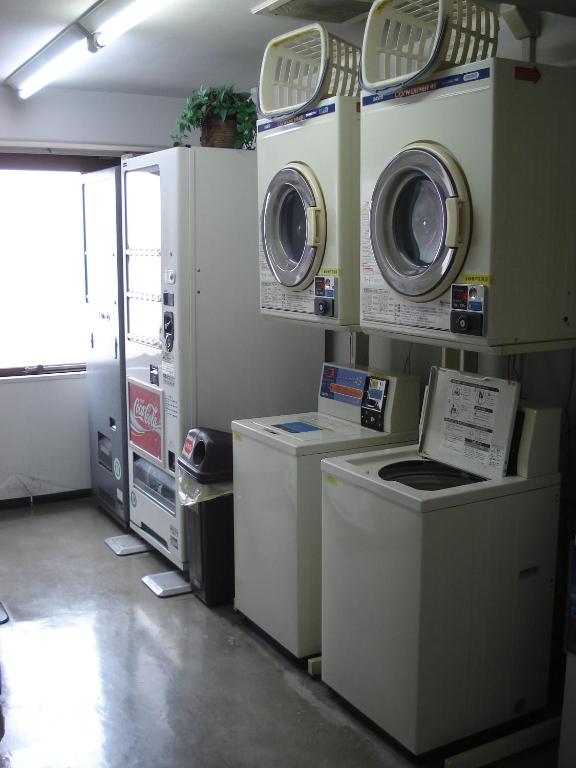 a laundry room with washers and dryers on display at Smile Hotel Sugamo in Tokyo