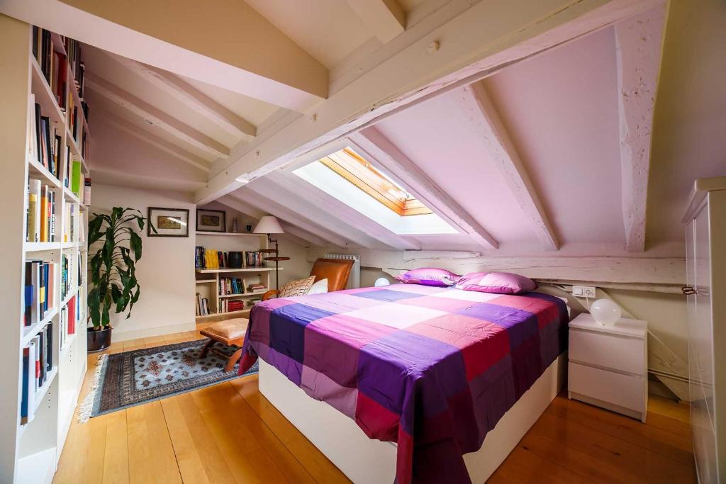 ein Schlafzimmer mit einem lila Bett im Dachgeschoss in der Unterkunft Elkano Room in San Sebastián