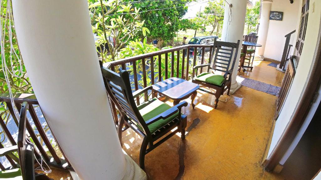 a balcony with two chairs and a table at Fort Dew Guest House in Galle