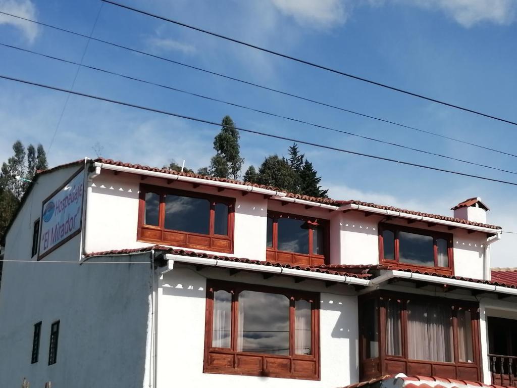 a white building with windows on top of it at Hospedaje El Mirador in Iza