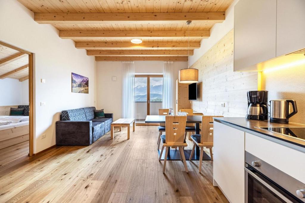 una cucina e un soggiorno con tavolo e sedie di Residence Stefansdorf a Brunico