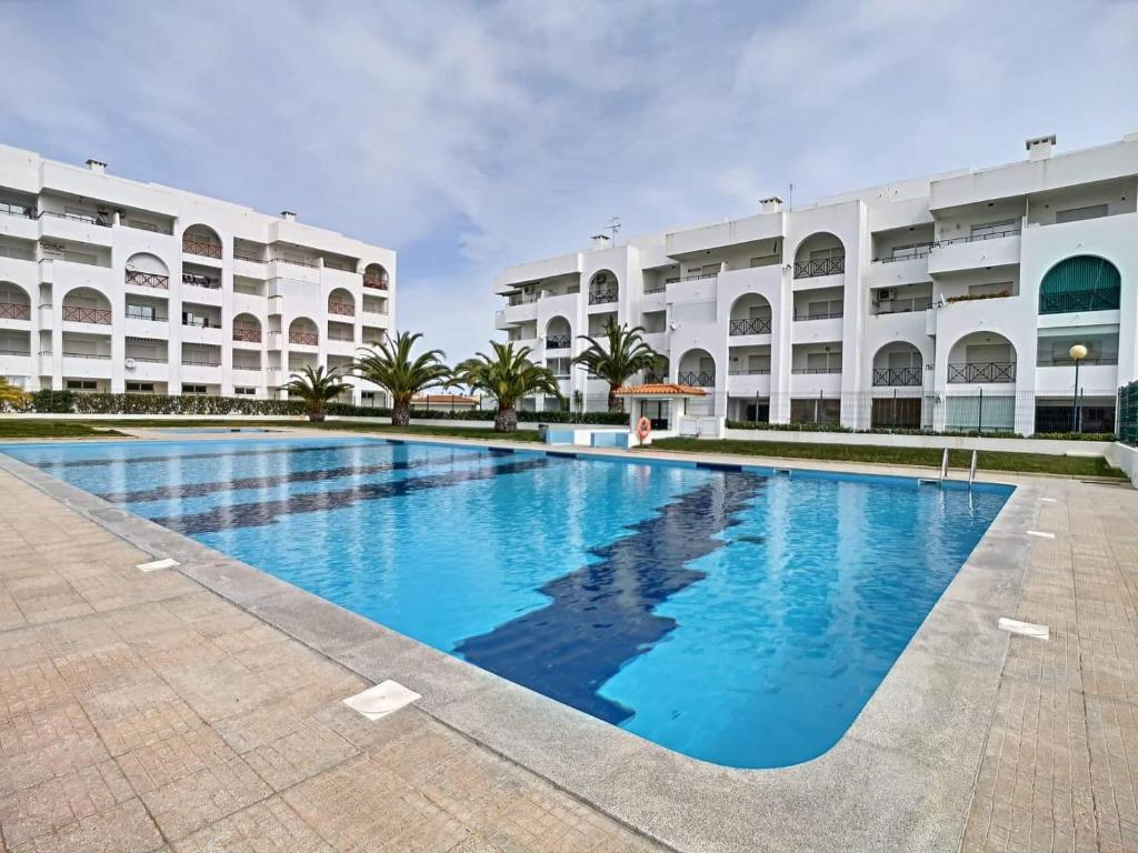 uma piscina em frente a um edifício em O Cantinho do Algarve em Porches