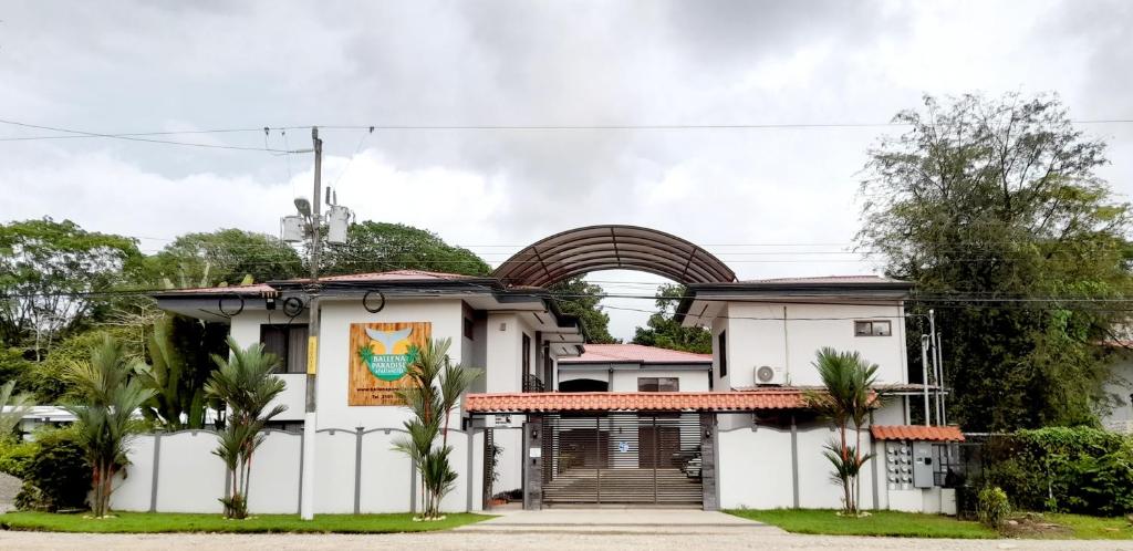 una casa blanca con una puerta y palmeras en Ballena Paradise Condos, en Uvita