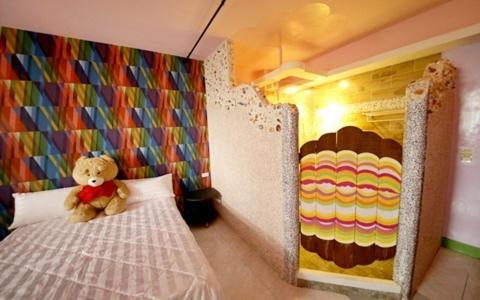 a teddy bear sitting on a bed in a room at Hi Young Castle in Hengchun South Gate