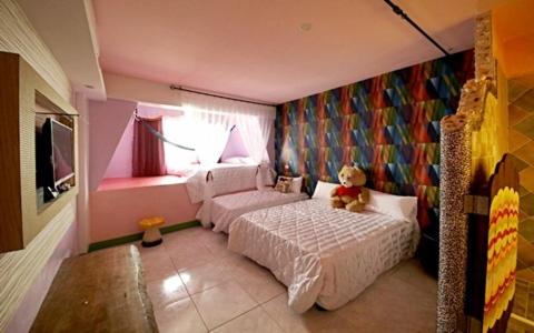 un dormitorio con un osito de peluche sentado en una cama en Hi Young Castle, en Hengchun