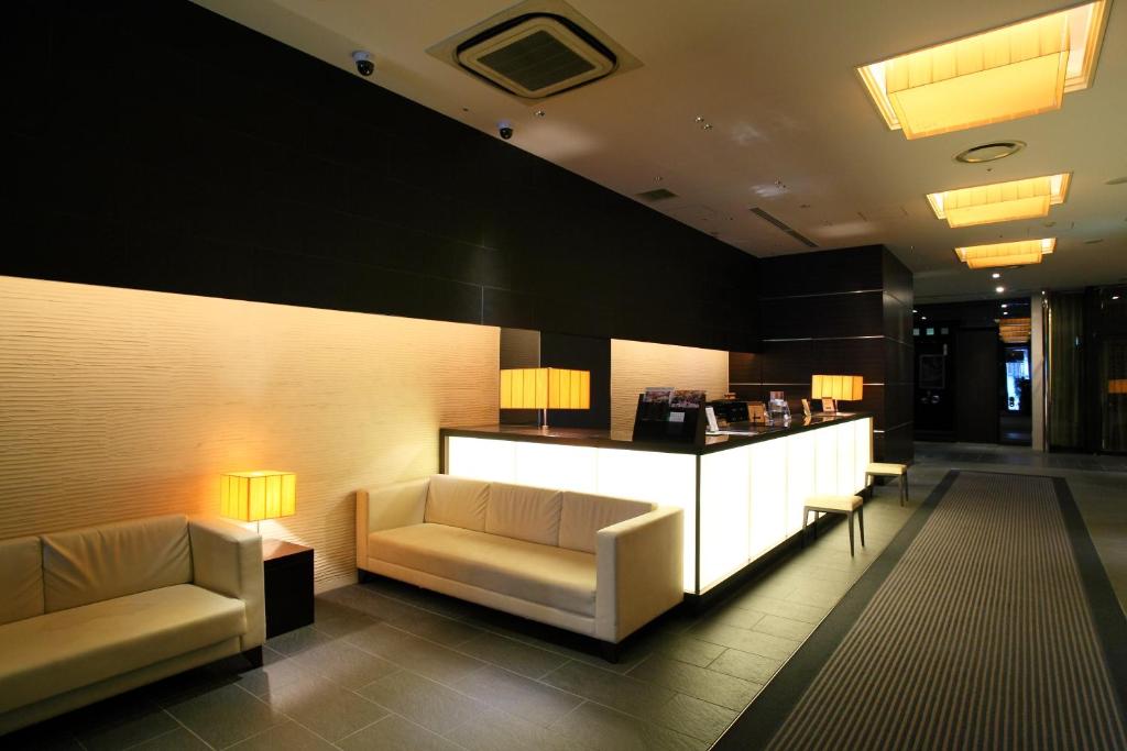 a lobby with two couches and a counter in a building at Lagunasuite Nagoya in Nagoya