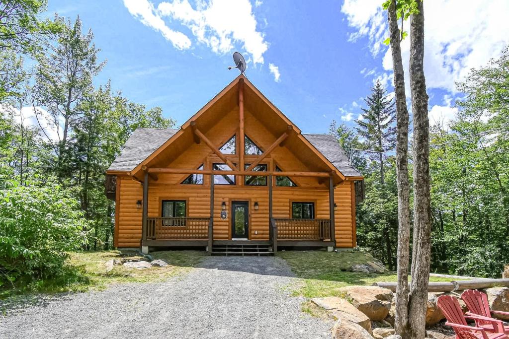 eine Blockhütte im Wald mit einer Veranda in der Unterkunft Brown Bear Lodge in Brownsburg