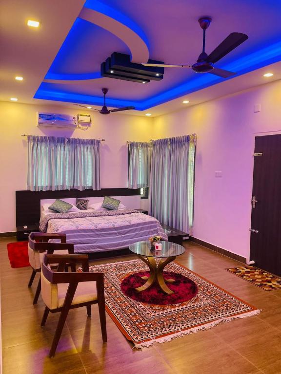 a bedroom with a bed and a table and blue lights at Castle Villa in Ernakulam