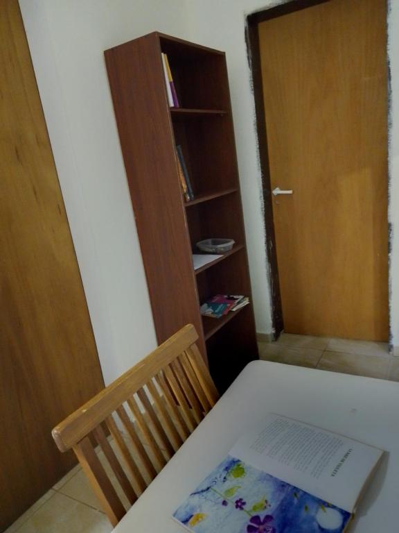 a room with a table and a chair and a book shelf at Laprida in Ramallo