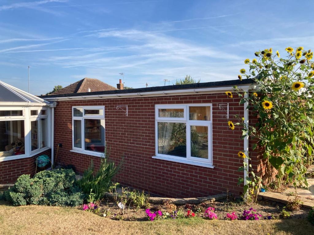 a red brick house with a sunflower at Delightful self-contained Annexe close to airport in Norwich