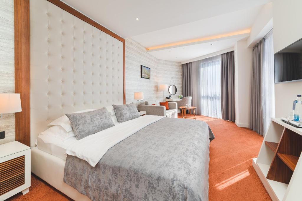 a hotel room with a large bed and a desk at Kalamper Hotel & Spa in Dobra Voda
