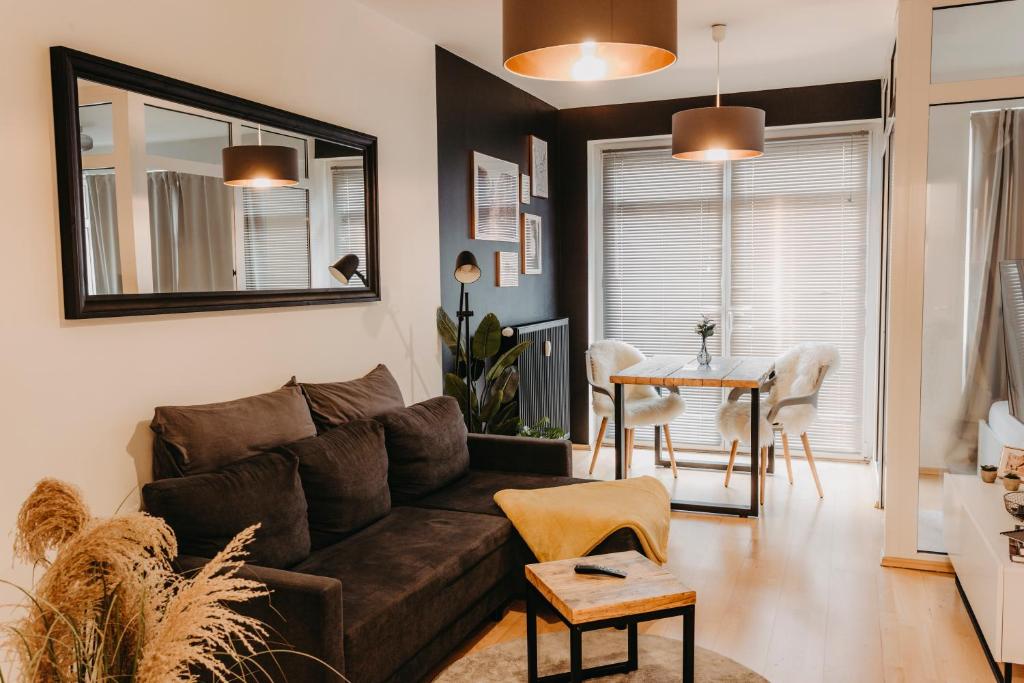 ein Wohnzimmer mit einem braunen Sofa und einem Tisch in der Unterkunft Stilvolle, gemütliche Wohnung mitten im ZENTRUM in Leipzig