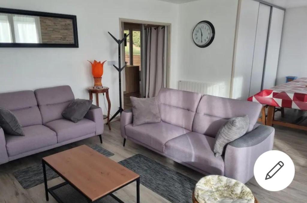 - un salon avec deux canapés violets et une table dans l'établissement Maison de Nicolas et Sonia, à Bort-les-Orgues