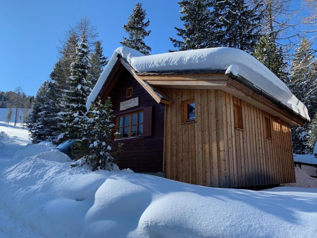 a small cabin with snow on top of it at Zirbenwald Chalet in Turracher Hohe